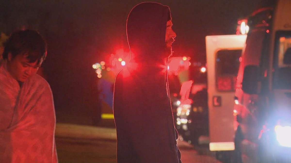 Jason Schurman waits outside after fire crews evacuated him from the home he is renting in Ogden Saturday morning.