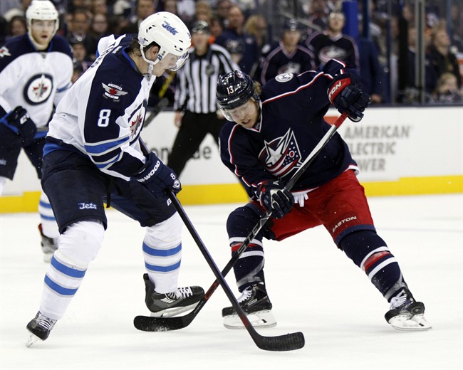 Columbus Blue Jackets' Cam Atkinson, right, works for the puck against Winnipeg Jets' Jacob Trouba during the second period of a in Columbus, Ohio, Saturday, Oct. 31, 2015. 