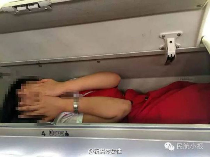 An image shared on the Chinese micro-blogging website Weibo shows a flight attendant who was purportedly made to climb into an overhead baggage compartment as a part of an initiation.