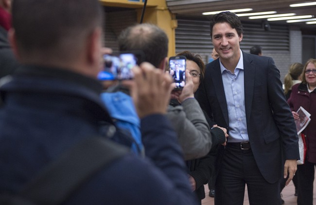 People take photos of prime minister-designate Justin Trudeau as he greets constituents at a subway station in his riding Tuesday, October 20, 2015 in Montreal, the morning after winning a majority government in the federal election.