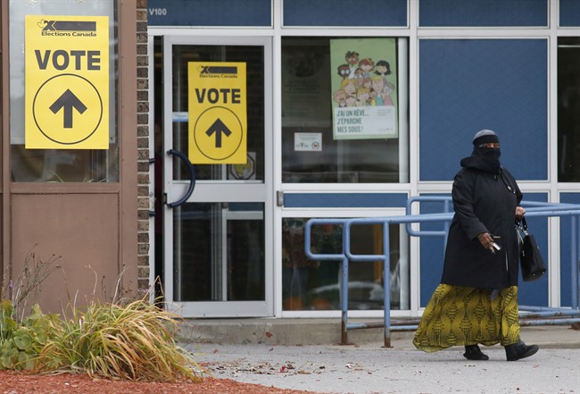 A woman wearing a niqab leaves the Ecole Marius-Barbeau polling station, in Ottawa, after casting her vote in the Canadian federal election on Monday, Oct. 19, 2015.