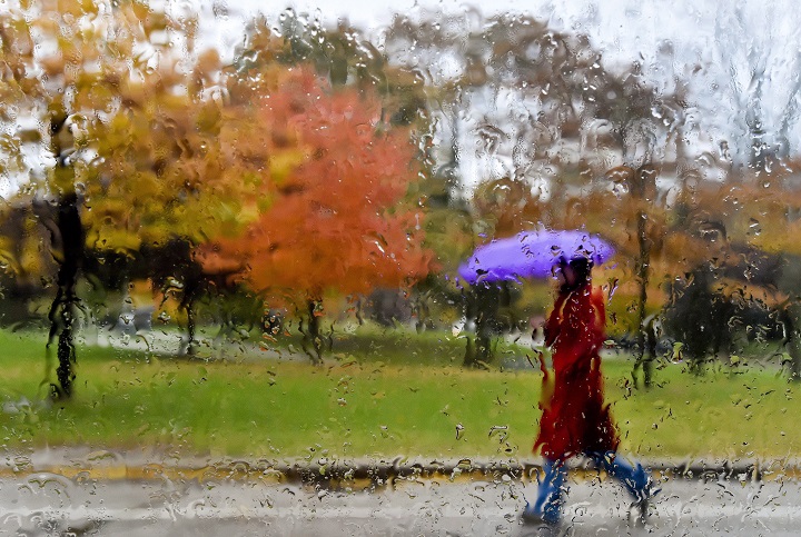 A women makes her way through the wet, rainy weather in Toronto on Wednesday, October 28, 2015.