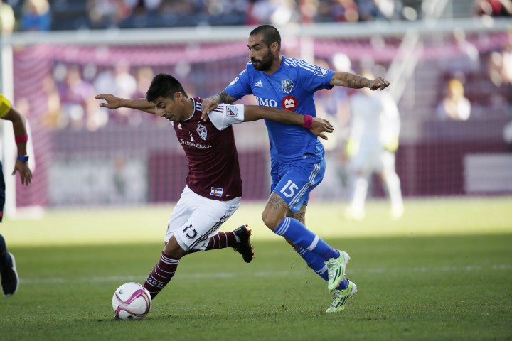Colorado Rapids midfielder Juan Ramirez, left, struggles to move the ball down the pitch as Montreal Impact forward Andres Romero covers in the first half of an MLS soccer match in Commerce City, Colo., Saturday, Oct. 10, 2015.