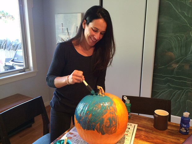Sherry Boguski paints a pumpkin teal. Her family is participating in the Teal Pumpkin Project, supporting children who suffer from food allergies.