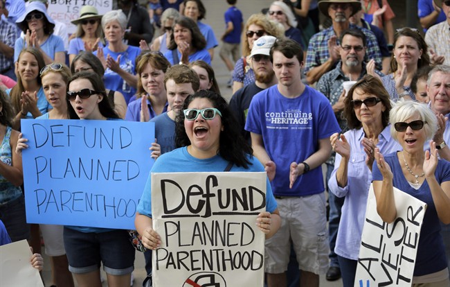 FILE - In this July 28, 2015, file photo, Erica Canaut, center, cheers as she and other anti-abortion activists rally on the steps of the Texas Capitol in Austin, Texas, to condemn the use in medical research of tissue samples obtained from aborted fetuses.
