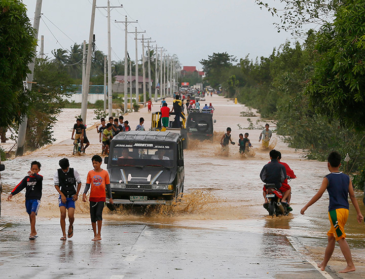 Residents wade through raging floodwaters brought about by Typhoon Koppu at Zaragosa Township, Nueva Ecija province, north of Manila, Philippines Monday, Oct. 19, 2015. 