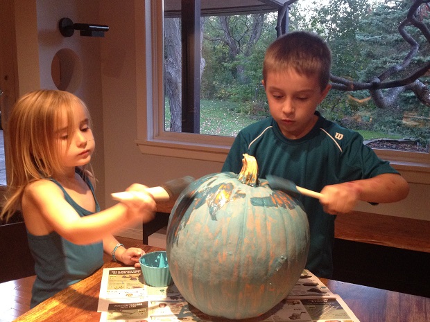 William and his sister paint their pumpkin teal.