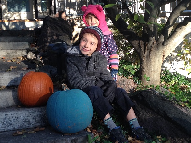 William and his sister Stella sit outside their house with the teal pumpkin they painted. William suffers from a severe peanut allergy.