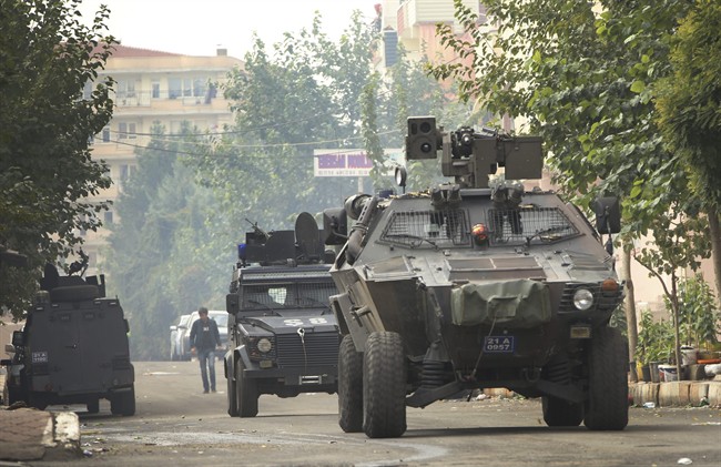 Armoured police vehicles patrol as they block a road leading to the site of armed clashes with militants in Diyarbakir, southeastern Turkey, Monday, Oct. 26, 2015. 