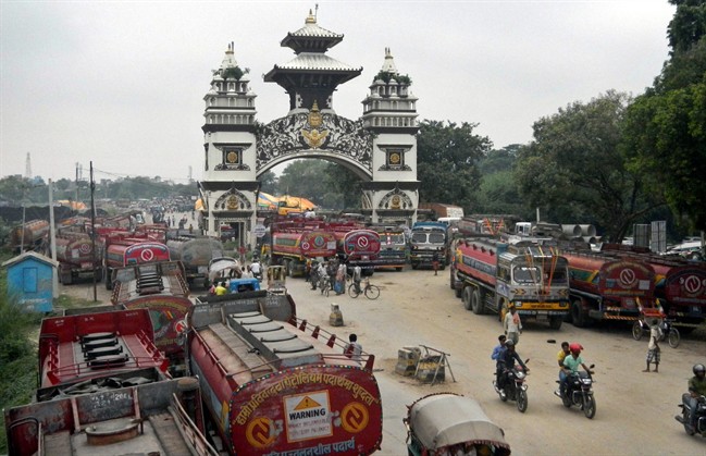 FILE - In this Thursday, Sept. 24, 2015 file photo, Nepalese oil tankers and commercial trucks stand stranded near a gate that marks the Nepalese border with India, in Birgunj, Nepal. 