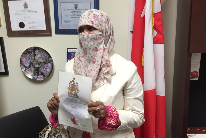 Mississauga, Ont., woman Zunera Ishaq, above, holds her Canadian citizenship certificate after swearing the oath on Oct. 9, 2015.