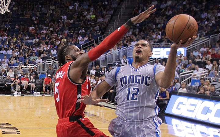 Orlando Magic forward Tobias Harris attempts a shot around Toronto Raptors forward DeMarre Carroll during the first half of an NBA basketball game Friday, Nov. 6, 2015, in Orlando, Fla.