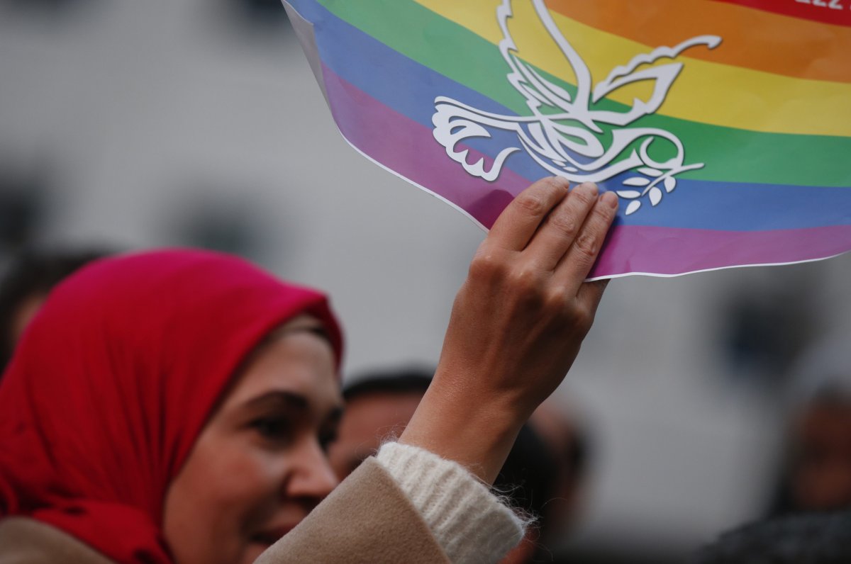A woman holds up a peace flag as members of the Milanese Muslim community gather in downtown Milan, Italy, Saturday, Nov. 21, 2015 to protest against violence.
