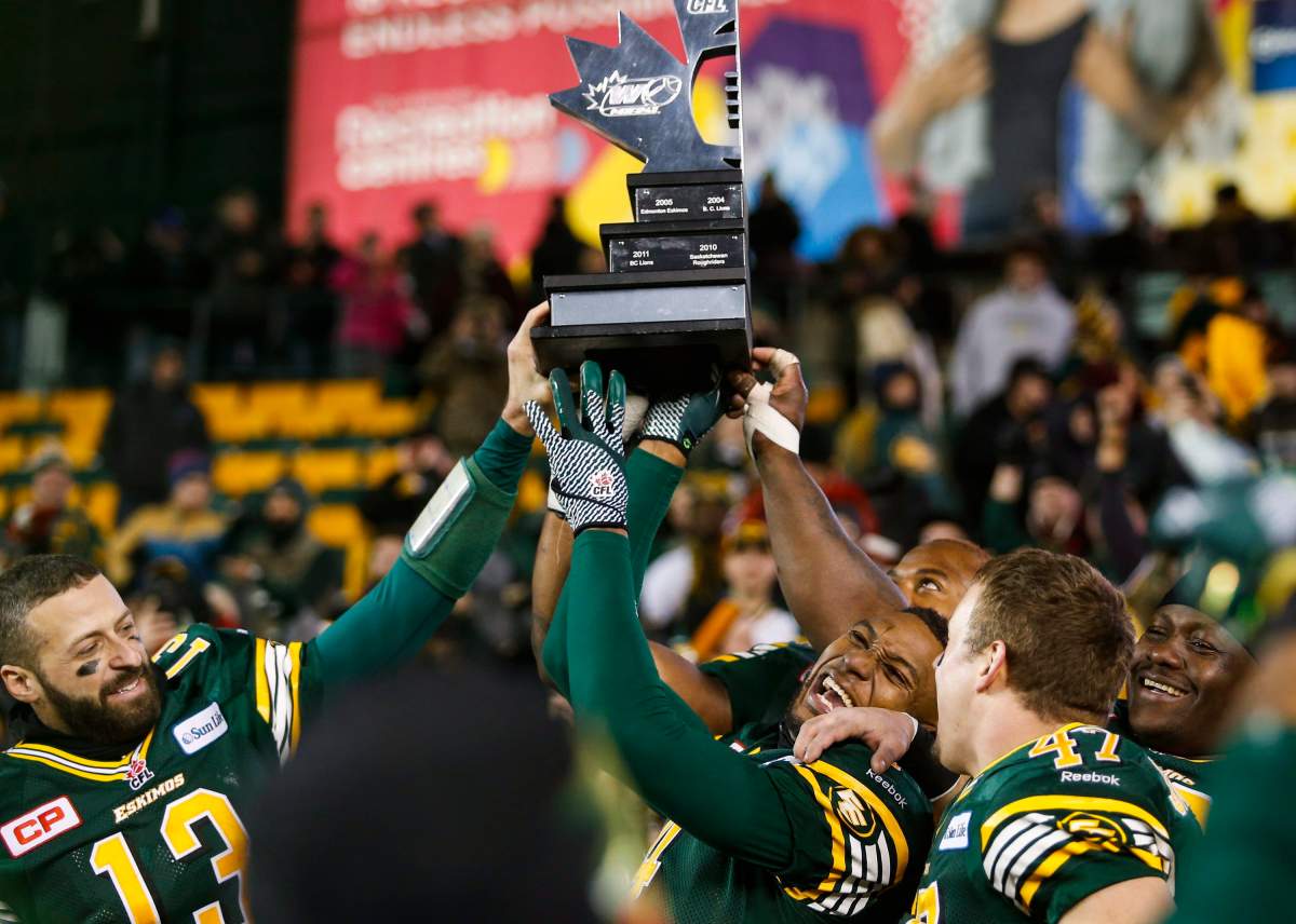 Edmonton Eskimos quarterback Mike Reilly, left, Adarius Bowman, centre, and J.C. Sherritt celebrate winning the CFL West Division final against the Calgary Stampeders in Edmonton, Sunday, Nov. 22, 2015.