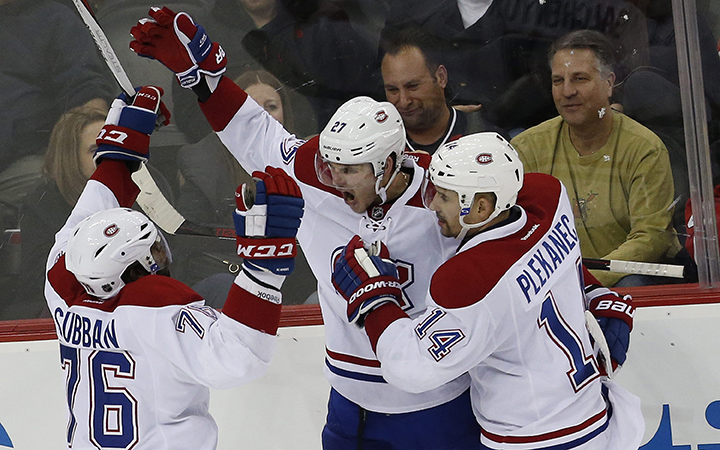 Montreal Canadiens center Alex Galchenyuk, center, celebrates with teammates P.K. Subban, left, and Tomas Plekanec, of the Czech Republic, after scoring a goal against the New Jersey Devils during the third period of an NHL hockey game, Friday, Nov. 27, 2015, in Newark, N.J. 