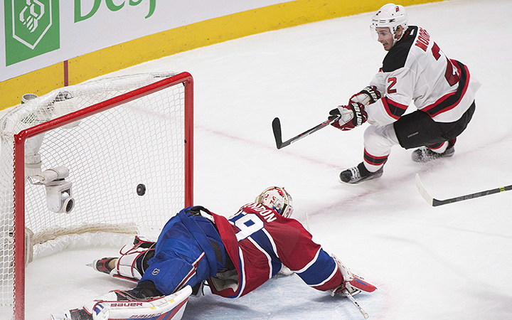 New Jersey Devils' John Moore scores on Montreal Canadiens goalie Mike Condon during overtime period NHL hockey action, in Montreal, on Saturday, Nov. 28, 2015. 