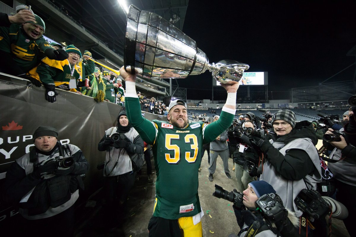 Edmonton Football Team long-snapper Ryan King is surrounded by photographers as he hoists the Grey Cup trophy after defeating the Ottawa Redblacks to win the 103rd Grey Cup in Winnipeg, Man., Sunday, Nov. 29, 2015. 