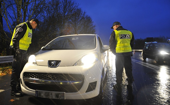 Police officers control a vehicle on the A31 motorway at the France-Luxembourg border, on November 19, 2015 in Entrange, eastern France. France revealed on November 19 it will spend an extra 600 million euros (USD 641 million) next year to ramp up security after the Paris attacks. President Francois Hollande announced this week that France is freezing plans to cut troop numbers through 2019. At the same time, the country will add 8,500 law enforcement jobs including 5,000 new police. 