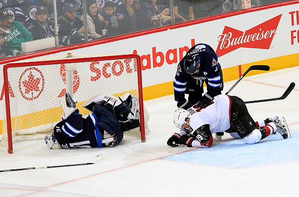Winnipeg Jets goalie Ondrej Pavelec lays in the net after being run into by Shane Doan of the Arizona Coyotes during the second at MTS Centre.