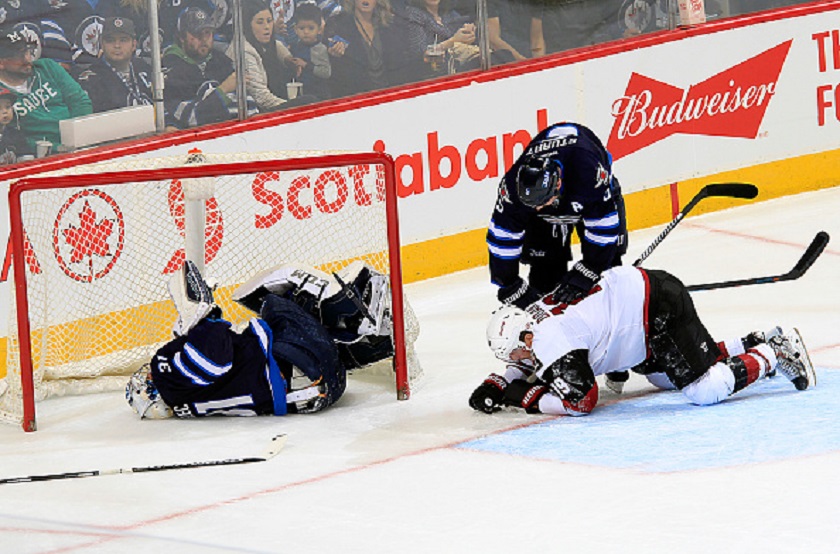 Goaltender Ondrej Pavelec #31 of the Winnipeg Jets lays in the net after being run into by Shane Doan #19 of the Arizona Coyotes during second period action at the MTS Centre on November 21, 2015 in Winnipeg, Manitoba, Canada.