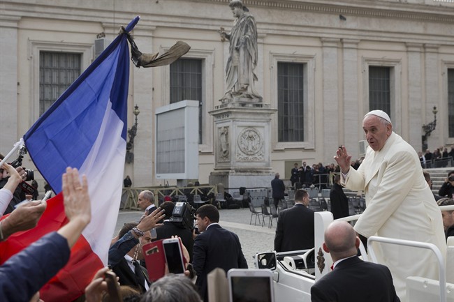 Pope Francis drives past a French flag as he leaves at the end of his weekly general audience, in St. Peter's Square, at the Vatican, Wednesday, Nov. 18, 2015.