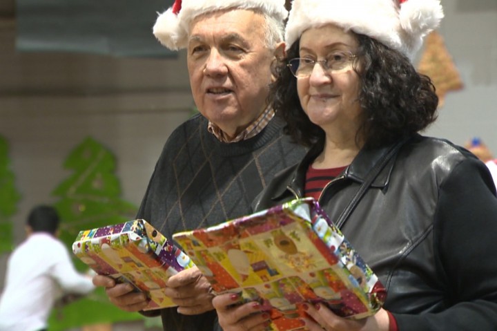Holding gifts for the Generations' Holiday Food and Toy Drive.