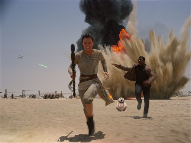 This photo provided by Disney shows Daisey Ridley as Rey, left, and John Boyega as Finn, in a scene from the new film, "Star Wars: Episode VII - The Force Awakens," directed by J.J. Abrams.