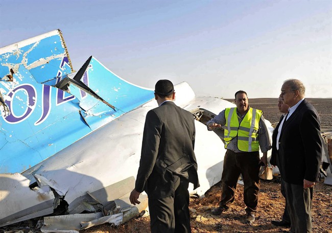 FILE - In this Saturday, Oct. 31, 2015, file photo released by the Prime Minister's office, Egyptian Prime Minister Sherif Ismail, right, looks at the remains of a crashed Russian passenger jet in Hassana, Egypt. Egyptian media have reacted with fury as Britain and the U.S. increasingly point to a bomb as the cause of the Russian plane crash, and many have hammered home to the public that their country is facing a Western conspiracy to scare off tourists and destroy the economy.