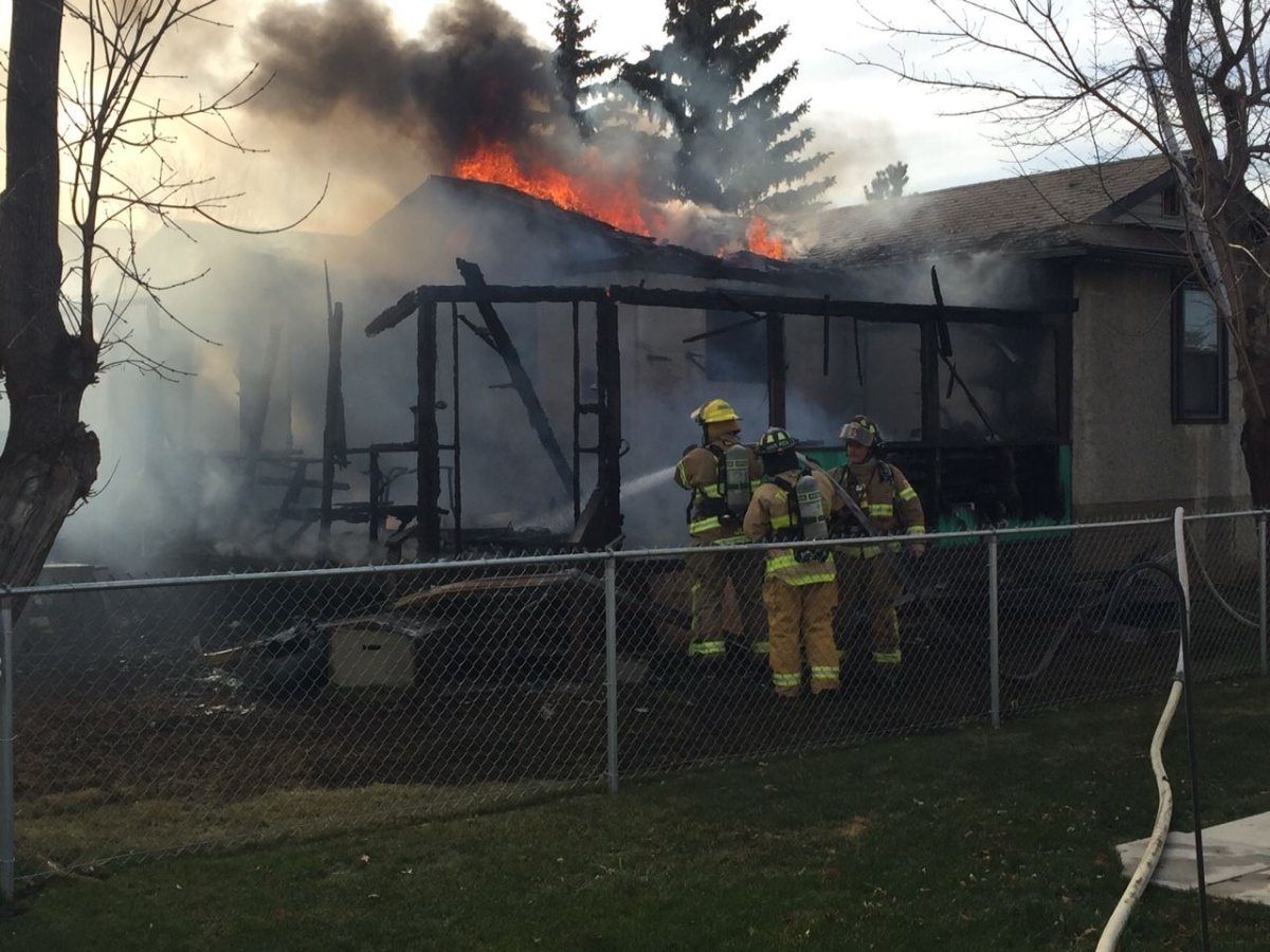 Firefighters battle a blaze in the town of Calmar, Alberta, Wednesday, Nov. 11, 2015. 