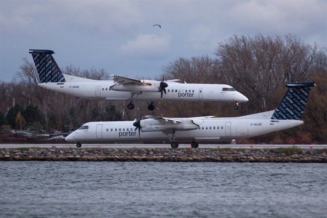 A Porter Airlines plane lands next to a taxiing plane at Toronto's Island Airport on Friday, November 13, 2015. The future of Bombardier's sole Canadian CSeries order is in serious doubt after Ottawa confirmed it would not allow passenger jets to fly out of Billy Bishop Toronto City Airport. 