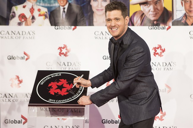 Michael Buble signs his plaque as he in inducted into Canada's Walk of Fame, during an event in Toronto on Saturday November 7, 2015.