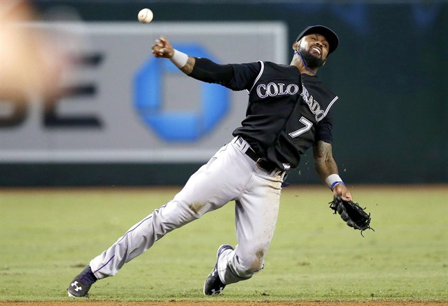 Colorado Rockies' Jose Reyes makes an off balance throw to first base to try in vain to get Arizona Diamondbacks' Jamie Romak during the eighth inning of a baseball game Wednesday, Sept. 30, 2015, in Phoenix. Major League Baseball and the Colorado Rockies are looking into a report that Reyes was arrested for assaulting his wife in Maui on Oct. 31.