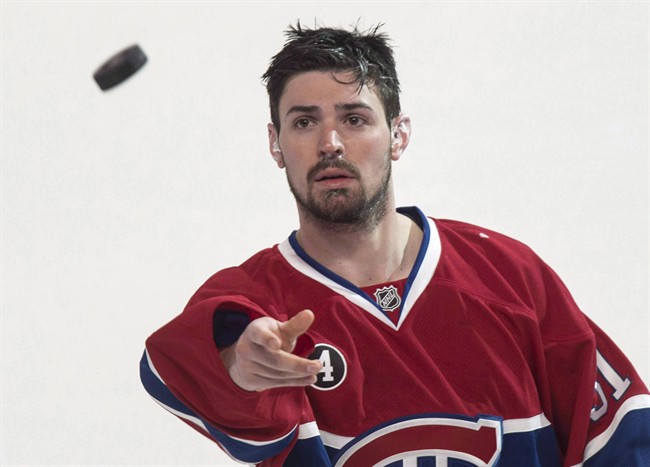 Montreal Canadiens' goalie Carey Price tosses a puck to the crowd following their 4-3 victory over the Detroit Red Wings during overtime in NHL hockey action on April 9, 2015 in Montreal.