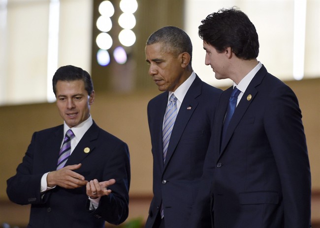 President Barack Obama, center, walks with Mexico's President Enrique Pena Nieto, left, Canada's Prime Minister Justin Trudeau, right, as they arrive for a group photo with leaders of the Asia-Pacific Economic Cooperation summit in Manila, Philippines, Thursday, Nov. 19, 2015.
