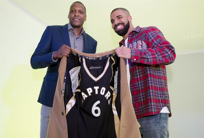 Toronto Raptors GM Masai Ujiri, left, and rapper Drake pose with a coat lined with a Raptors jersey at Drake Night prior to NBA basketball action between the Raptors and Cleveland Cavaliers in Toronto on Wednesday, November 25, 2015. THE CANADIAN PRESS/Darren Calabrese.