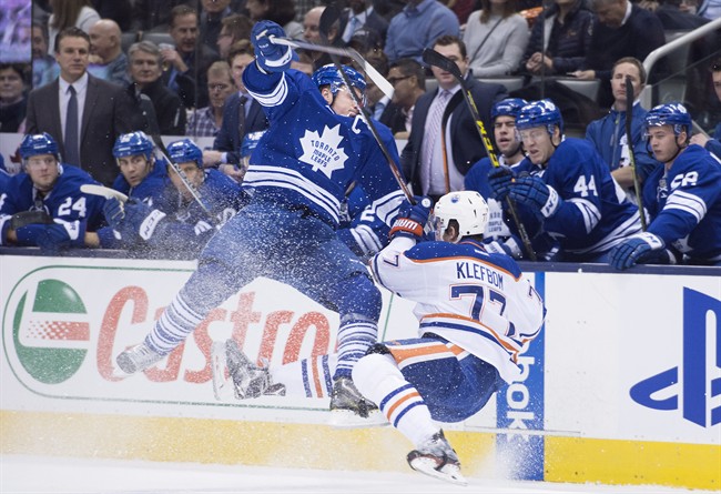 Toronto Maple Leafs' Dion Phaneuf, left, and Edmonton Oilers' Oscar Klefbom collide during first period NHL hockey action in Toronto on Monday, November 30, 2015.