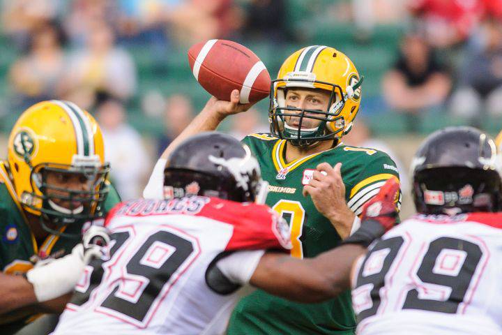Mike Reilly #13 of the Edmonton Eskimos looks up field for a teammate to pass to during a CFL game against the Calgary Stampeders at Commonwealth Stadium on July 24, 2014 in Edmonton, Alberta, Canada.