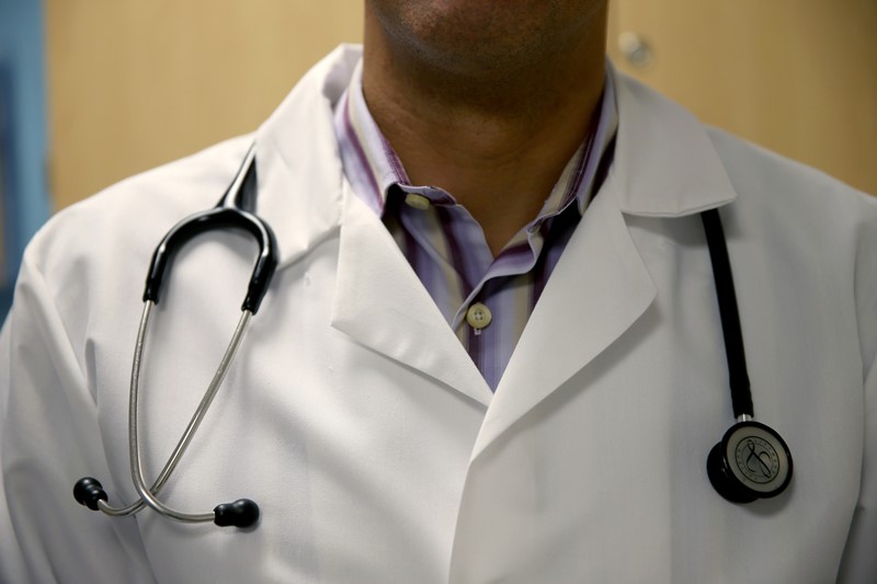  A doctor wears a stethoscope as he see a patient for a measles vaccination during a visit to the Miami Children's Hospital on June 02, 2014 in Miami, Florida.