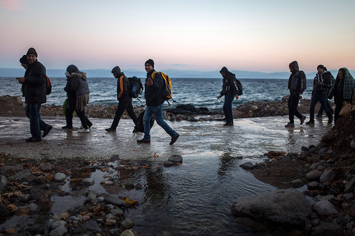 Afghan refugees walk on a beach after their arrival from the Turkish coast to the northeastern Greek island of Lesbos, on Monday, Nov. 30, 2015. 