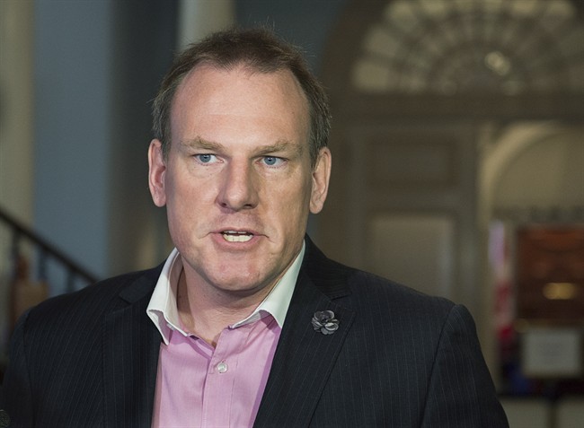 Andrew Younger, the former Nova Scotia environment minister expelled from the Liberal caucus, talks with reporters at the legislature in Halifax on Tuesday, Nov. 24, 2015.