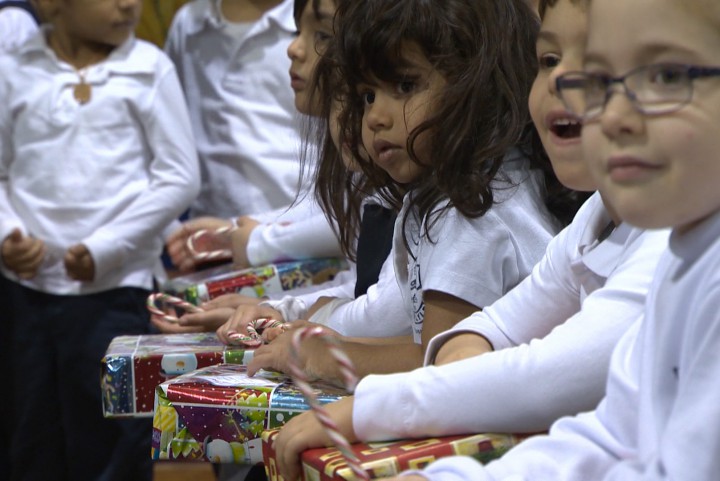 Children sit with their toys at the Generations' Holiday Food and Toy Drive.