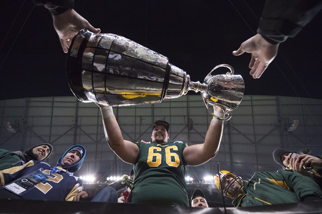 Edmonton Eskimos' Matthew O'Donnell takes the Grey Cup into the stands with the fans following his teams win over the Ottawa Redblacks of the 103rd Grey Cup in Winnipeg, Man. Sunday, Nov. 29, 2015.