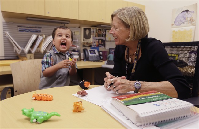 In a photo from Thursday, Oct. 22, 2015, in Ann Arbor, Mich., Grant Hasse yells out a word next to Lynn Driver, a speech-language pathologist at the University of Michigan's C.S. Mott Children's Hospital. Green performed Hasse's first surgery during the C-section. The bright-eyed boy with a charming smile was born with two very rare conditions _ one that's usually fatal, the other that should have left him unable to talk. But at almost 4 years old, he's a healthy bundle of energy after 36 surgeries, including an innovative operation to create a voice box where there was none. (AP Photo/Carlos Osorio).