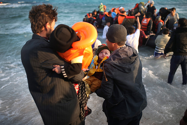 Refugees and migrants abort their effort on a dingy as they set out, trying to travel from the Turkish coast to the Greek island of Chios, near Cesme, Turkey, Saturday, Oct. 31, 2015. 