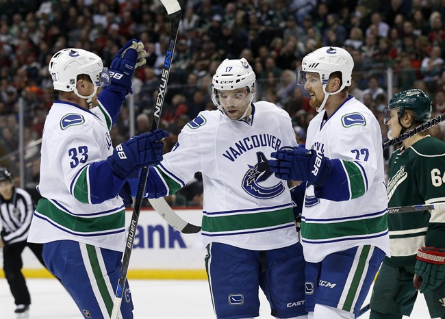 Vancouver Canucks right wing Radim Vrbata, centre, of the Czech Republic, celebrates with teammates Daniel Sedin, right, of Sweden, and Henrik Sedin, left, of Sweden, after scoring on Minnesota Wild goalie Devan Dubnyk during the second period of an NHL hockey game in St. Paul, Minn., Wednesday, Nov. 25, 2015. 
