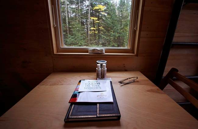 In this Tuesday, Oct. 20, 2015 photo, a guest register and information regarding property rentals are seen on a kitchen table at a tiny house in Croydon, N.H. 
