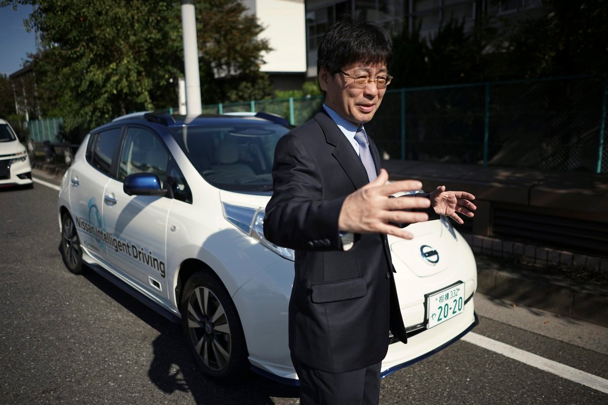 Nissan General Manager Tetsuya Iijima explains a self-driving prototype vehicle after its test drive in Tokyo, Tuesday, Nov. 3, 2015. Nissan's "intelligent driving" feature is smart enough to navigate intersections without lane markers. It also brakes safely to a stop without crashing into the vehicle in front, and it knows the difference between a red light and a tail-lamp.