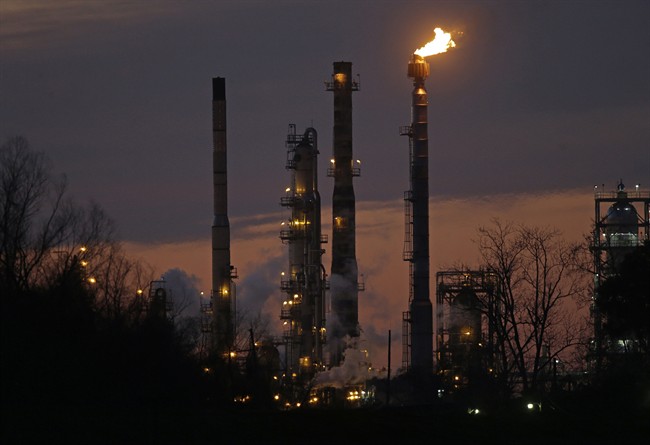 Stacks and burn-off from the Exxon Mobil refinery are seen at dusk in St. Bernard Parish, La.