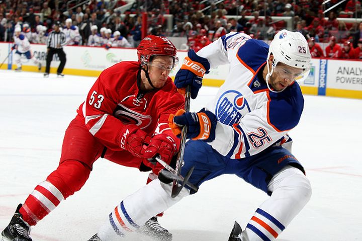 Jeff Skinner #53 of the Carolina Hurricanes and Darnell Nurse #25 of the Edmonton Oilers battle for the puck during a NHL game at PNC Arena on November 25, 2015 in Raleigh, North Carolina. 