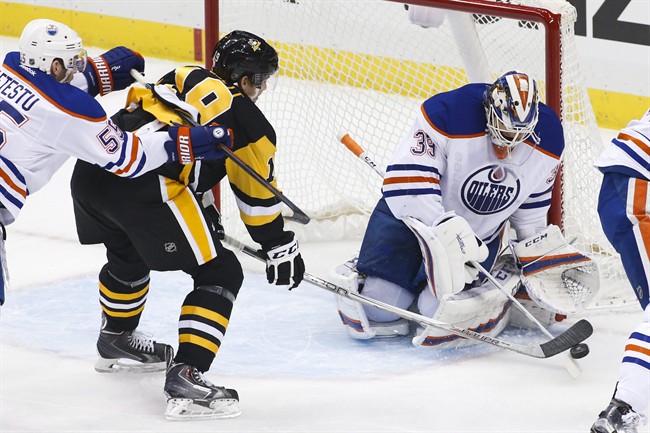 Pittsburgh Penguins' Beau Bennett (19) cannot get a shot past Edmonton Oilers goalie Anders Nilsson (39) with Mark Letestu (55) defending during the first period of an NHL hockey game in Pittsburgh, Saturday, Nov. 28, 2015.